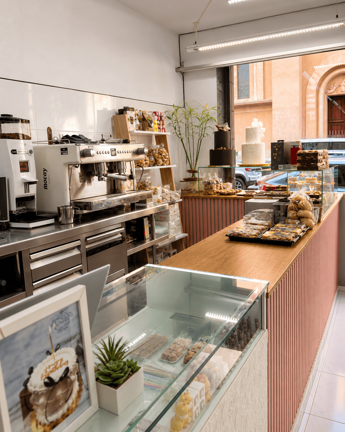 Mostrador de La Dulzura con vitrina de pastelería y máquina de café